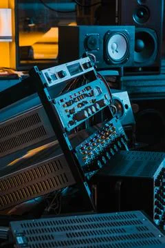 Tilted array of rackmount audio gear with studio speakers in background Stock Photos