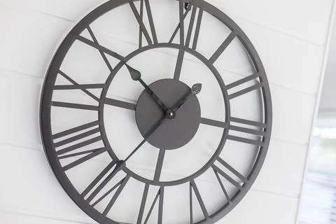 Tilted Close up of a Large Designer Wall Clock Placed Outside a Kitchen Area Stock Photos