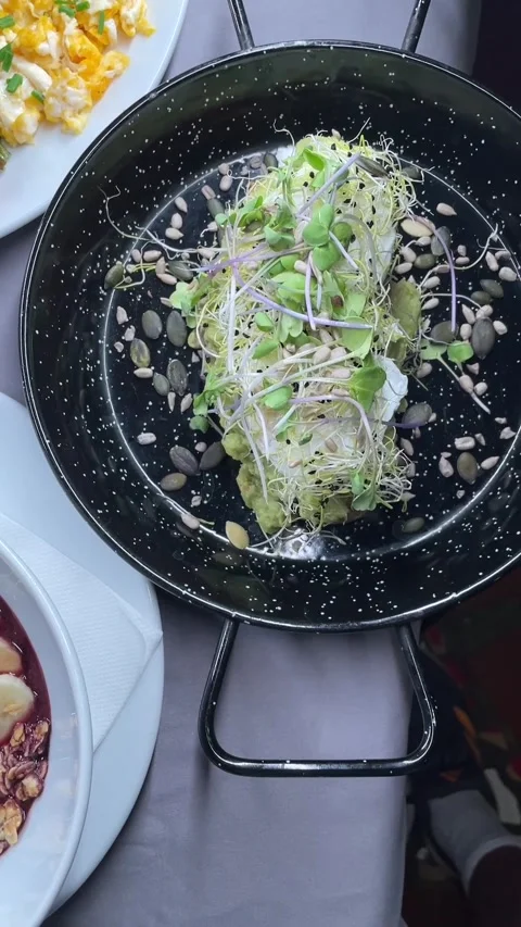 Tilted overhead breakfast spread with plated bowls, toast, omelette, and sides Stock Footage 341626355