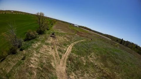 Tilted overhead view of a moving tractor and an ATV on trails Stock Photos