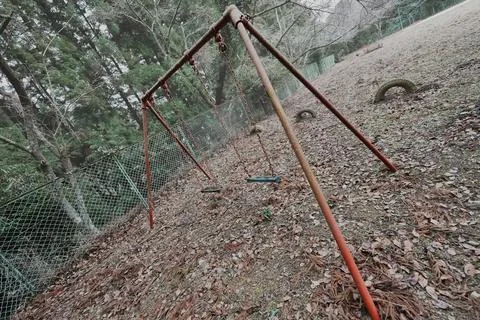 Tilted Rusty Swing Frame in an Abandoned Playground – Unstable Silence Stockfoto's