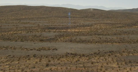 Tilted shot tracking quickly down rugged desert lands, drone, helicopter aerial Stock Footage 115321822