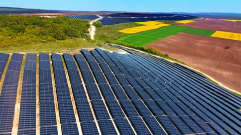 Tilted solar modules on slope with patchwork crops beyond Stock-Footage 335694990