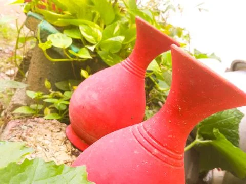 A tilted view of red colored earthen pots placed in a garden Stock Photos