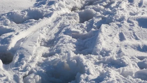 Tilting along trace in snow and people on the ice midst a lake Stock-Footage 70389863