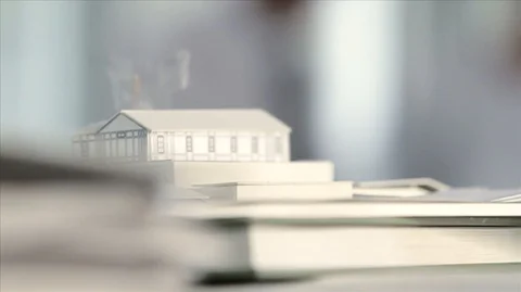 Tilting up from architectural scale model to portrait of three business Video stock 88438259