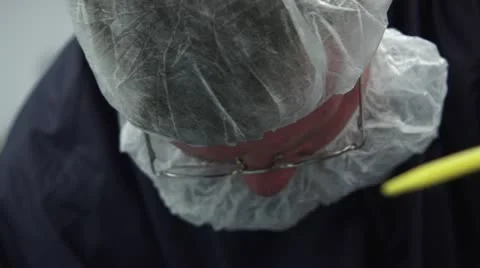 Tilting between face and hands working with small parts in Cleanroom Stock Footage 10895746