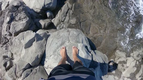 Tilting camera up from feet to see the view of Makaluapuna Point, Hawaii Stock Footage 131333939