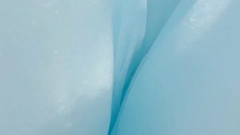 Tilting the camera upwards from a small crevasse with deep blue and white ice. Stock Footage 182885067