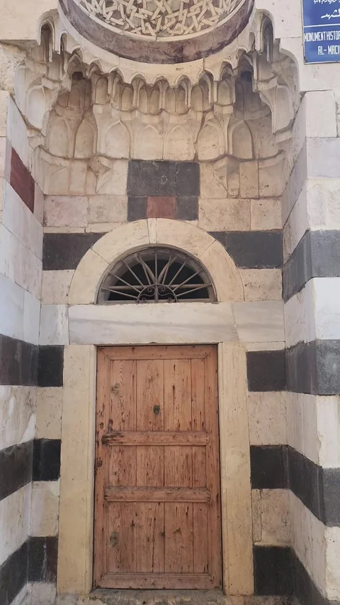 A tilting, close-up shot of a small door and an arched window Stock Footage 314314031