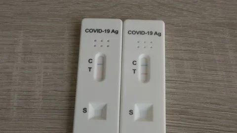 Tilting down to a Covid 19 positive vs negative antigen tests Stock Footage