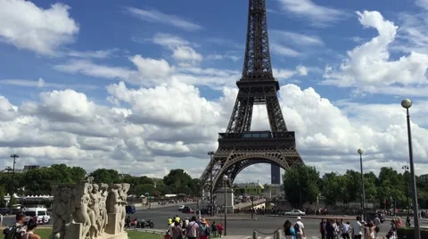 Tilting down from Eiffel Tower to the ground with sunny day backdrop Stock Footage 55516807