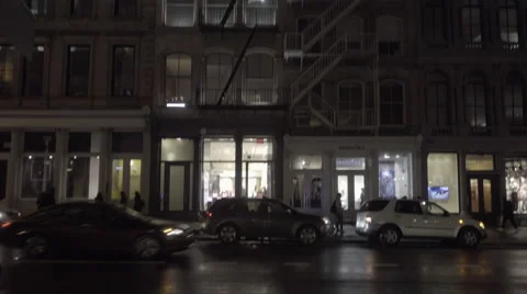 Tilting down from fire escape on SoHo building to cars driving down Broadway NYC Stock Footage 58996238