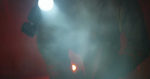 Tilting down on fire fighter kneeling in smoke filled room - medium shot Stock Footage 108821109