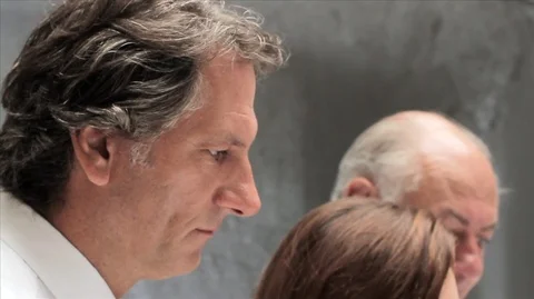 Tilting down to four colleagues looking seriously at building plans. Vídeos de archivo 88438244