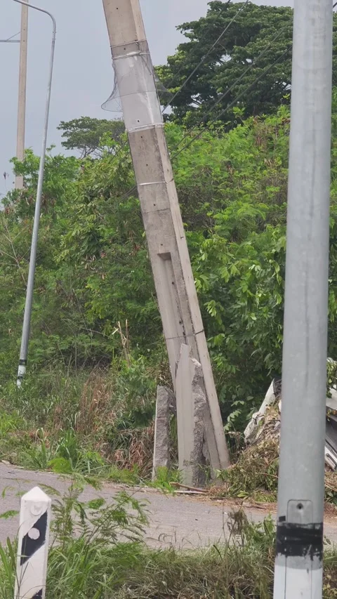 Tilting down video of a severely broken concrete power pole leaning. Stock Footage 338194767