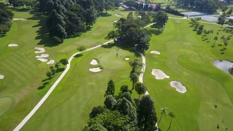 Tilting drone shot of people playing golf on course Kuala Lumpur, Malaysia Stock Footage
