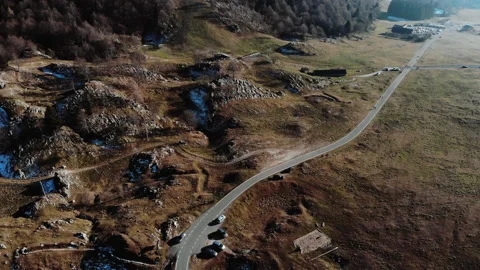 Tilting drone shot of winding road in green Summer Stock Footage 188414547