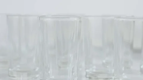 Tilting on empty transparent spirits or liquor drink glasses Stock Footage 75843055