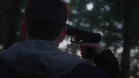 Tilting Headshot View of Man Committing Suicide in Dark Woods at Sunset Stock Footage 208798768