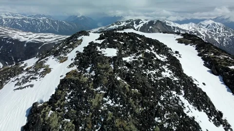 Tilting over Mountain Summit to Frozen Lake, Aerial View Stock Footage 289555953