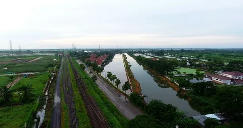 Tilting up from rural green fields with fish ponds on the outskirts of thaila Stock Footage 90879267