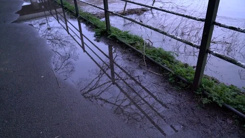 Tilting shot of flooded path to reveal extent of rising water levels, UK, 4k Video stock 87141925