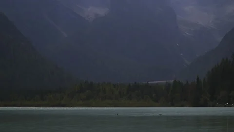 Tilting shot of scenic mountains in clouds above mountain lake, Dolomites, Italy Stock Footage 146170868