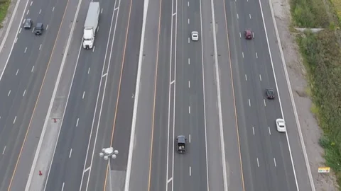 Tilting up as traffic goes by on freeway.  Fields on both side city in distance Stock Footage 250489781