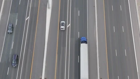 Tilting up as traffic goes by on freeway.  Fields on both side city in distance Stock Footage 250489782