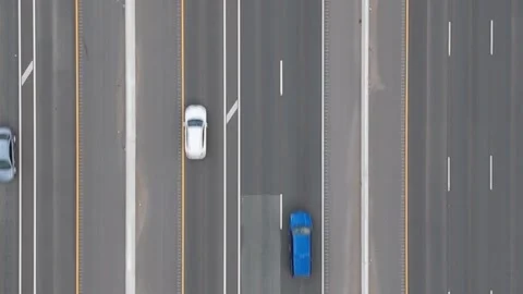 Tilting up as traffic goes by on freeway.  Fields on both side city in distance Stock Footage 250489785