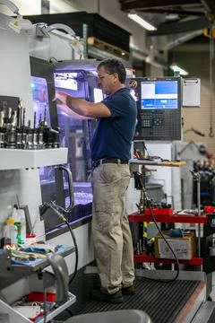 Tim Evans, a mechanical engineering technician, uses a computer numerical ... Stock Photos