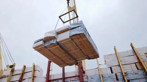Timber Cargo Loading - Crane Lifts Heavy Lumber Bundles Above Ship Hold at Port Stock Footage 344079638