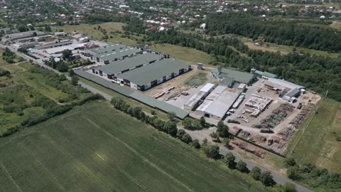 Timber factory with storage yards and metal rooftops – drone shot Video stock 316582853