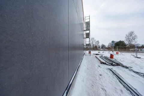 Timber frame house construction with matte grey facade in winter Stock Photos