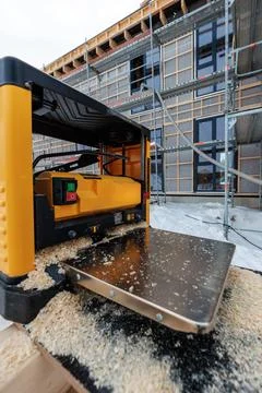 Timber frame house construction with planer, scaffolding, and snow Fotos de archivo