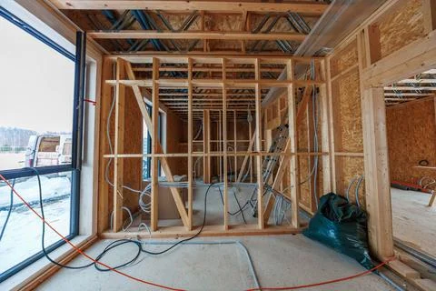 Timber frame house interior build with studs, conduits, and ductwork Stock Photos