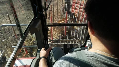 Timber loader driver unloading timber into a stack Stockbeeldmateriaal 294061723