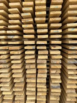 Timber planks stacked, building materials. wooden boards at lumberyard. Stock Photos
