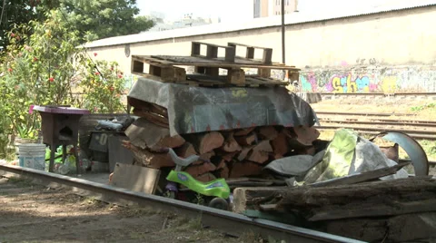 Timber stack next to railway track with dinner table set and washing above Stock Footage 39453515
