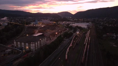 Timber storage yard at a paper mill in Austria, with freight trains at dawn Video stock 344694911