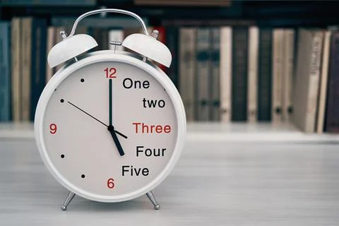 Time 5 five or 17 seventeen hours on a desk clock Stock Photos