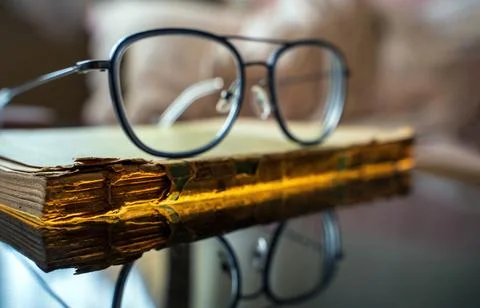 Time and knowledge concept, An eye glasses or spectacles kept on top of a rea Stock Photos