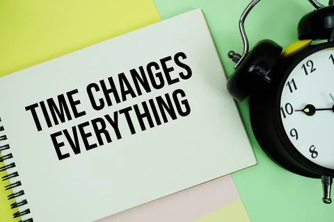 Time Changes Everything text written on notepad with alarm clock on pastel .. Stock Photos