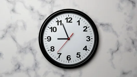 The Time On The Clock Nine. Black Clock With The Red Arrow With The Arabic Numer Stock Footage 128741549