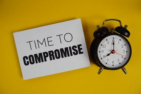 Time to Compromise text with alarm clock on yellow background Stock Photos