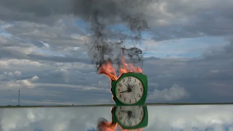 Time concept. Burning  old retro green alarm clock on mirror in space Video stock 77803013