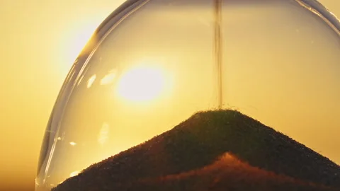 Time concept hourglass close up on blurred background of golden sunset sun Stock Footage 263310788