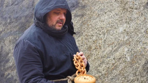 Time concept - medieval man hold fast running clock and speaks Stock Footage 104564848