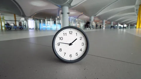 Time crunch concept with clock hands racing on modern airport terminal floor Stock Footage 345553431